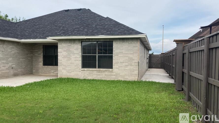 A house with a grey roof and a fence in front of it.
