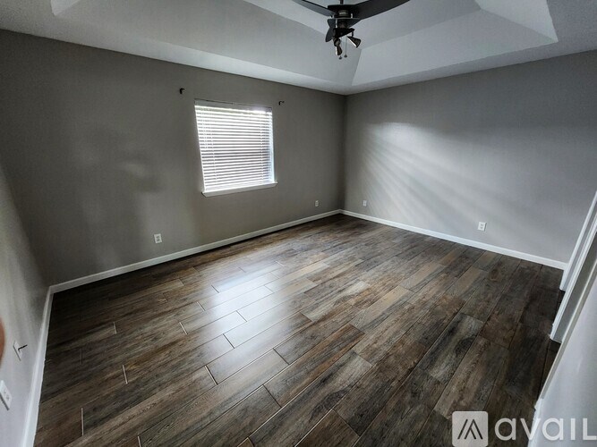 A room with wooden flooring and a ceiling fan.