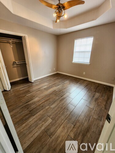 A room with wooden flooring and a ceiling fan.