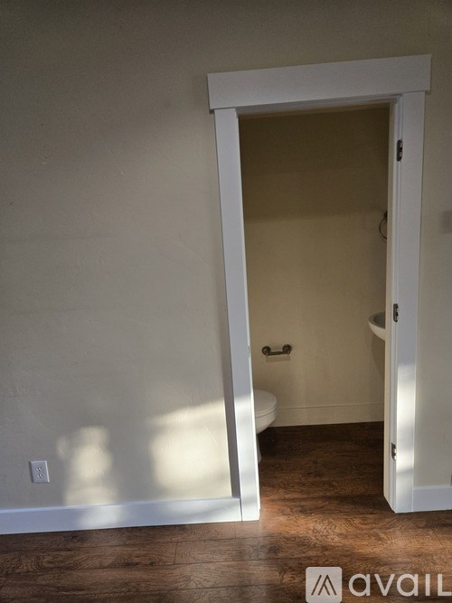 A white door is open to a bathroom.