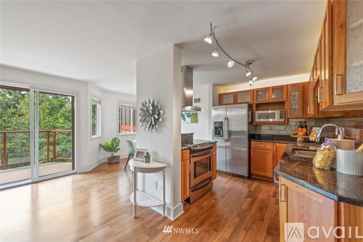 A kitchen with wooden cabinets and a black countertop.