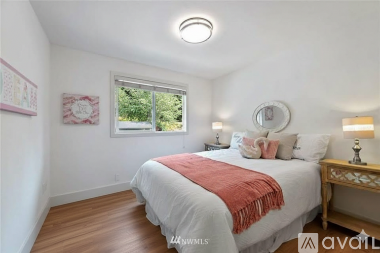 A bedroom with a bed, a window, and a carpet.