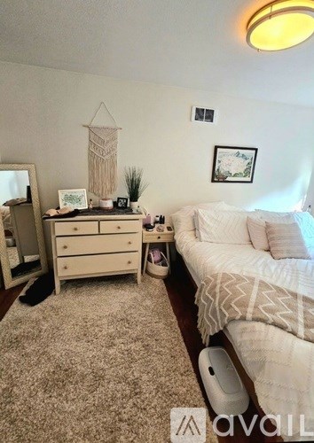 A bedroom with a bed, dresser, and mirror.