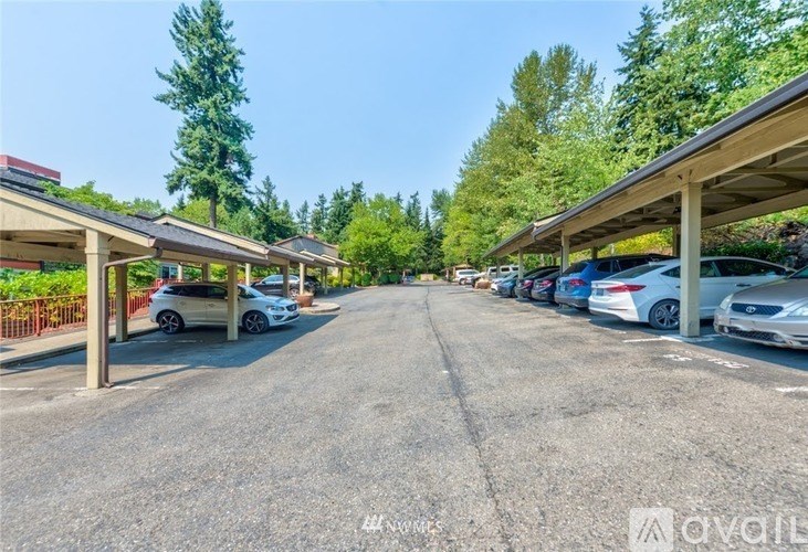 A parking lot with cars parked under a sheltered area.