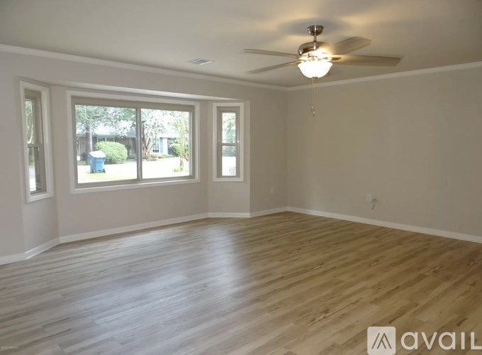 A room with wooden floors and a ceiling fan.