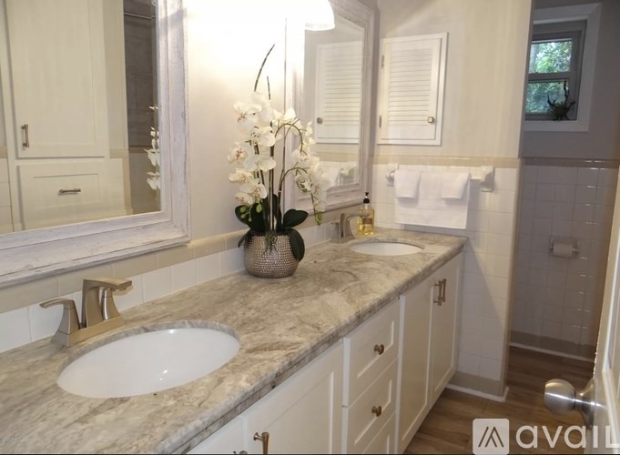 A bathroom with a marble countertop and a white sink.