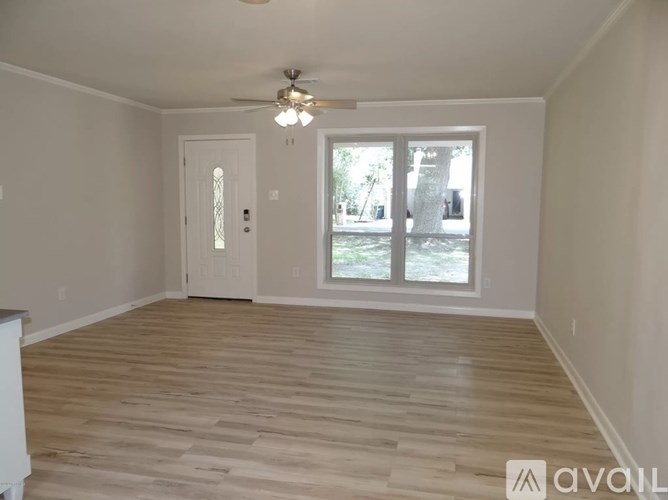 A room with wooden flooring and a ceiling fan.