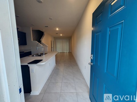 A kitchen with a blue door and white cabinets.