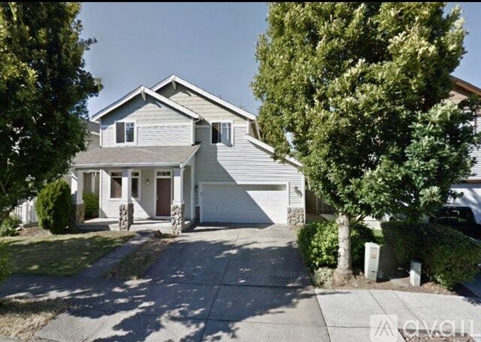 A two-story house with a garage and a driveway.