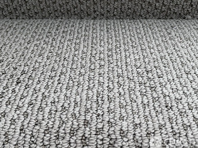 A grey carpet with a pattern of small circles.