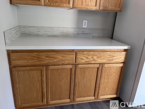 A kitchen with wooden cabinets and a marble countertop.