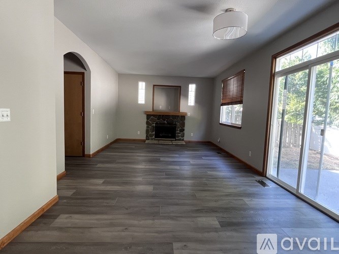 A spacious living room with a fireplace and sliding glass doors.