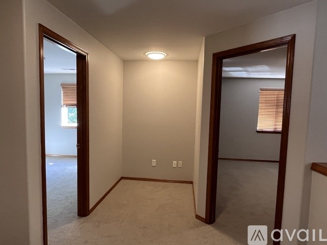 A room with a carpeted floor and a doorway leading to another room.