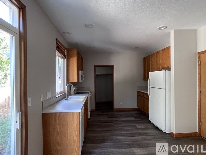 A kitchen with wooden cabinets and a white refrigerator.