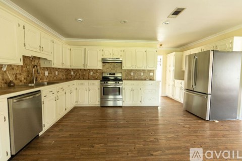 A kitchen with white cabinets and stainless steel appliances.