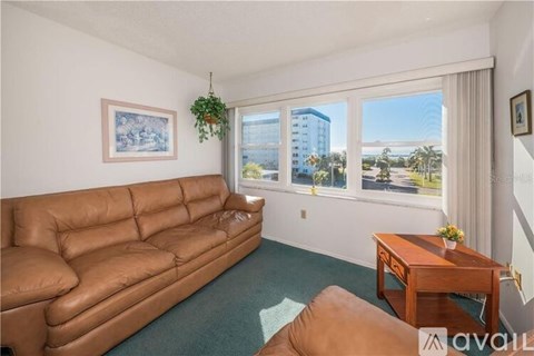 A living room with a brown leather couch and a wooden coffee table.