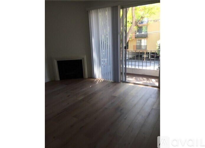 A room with wooden floors and a sliding door leading outside.