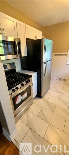 A kitchen with a black fridge and white cabinets.