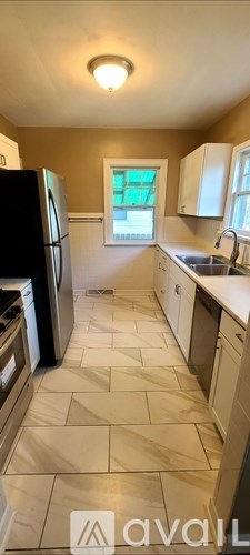 A kitchen with a black fridge and white cabinets.