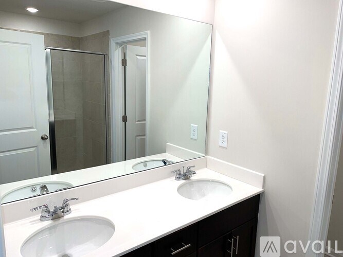 A bathroom with a white countertop and two sinks.