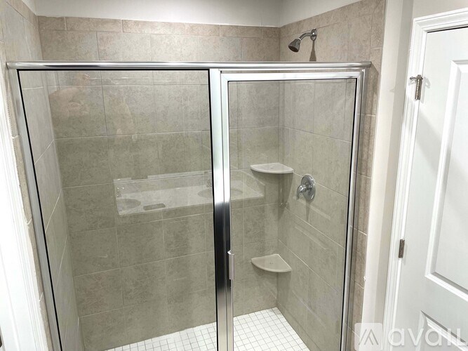 A shower stall with a glass door is in a bathroom.