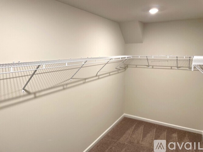 A room with a long metal shelf and a carpeted floor.