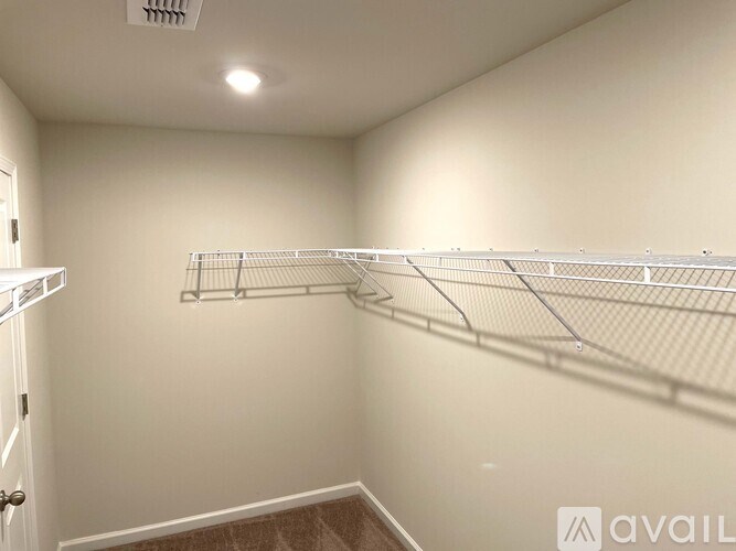 Empty room with white walls and a carpeted floor.