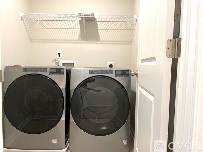 Two front load washing machines in a small laundry room.