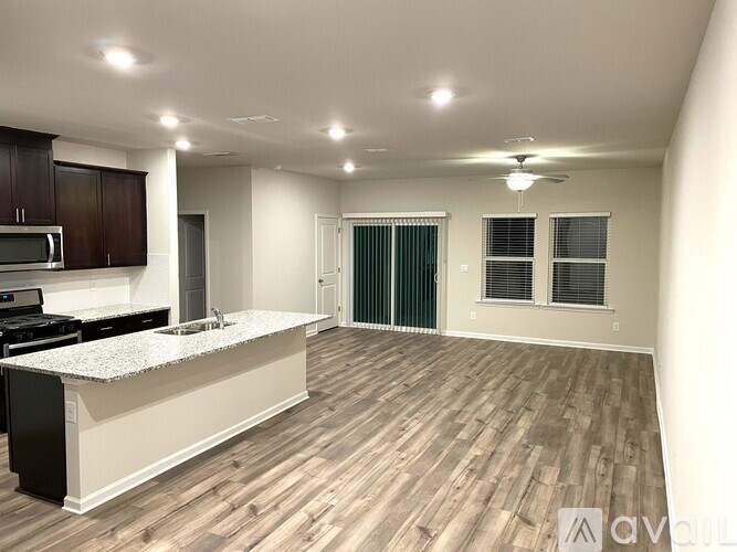A spacious kitchen with wooden flooring and a white countertop.