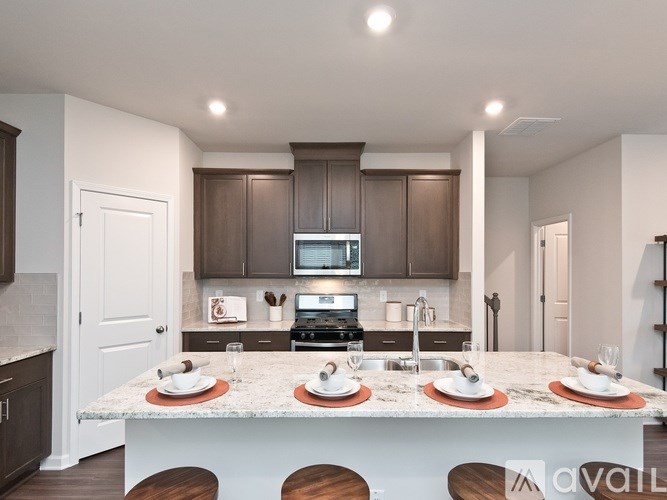 A kitchen with brown cabinets and a white island with plates on it.