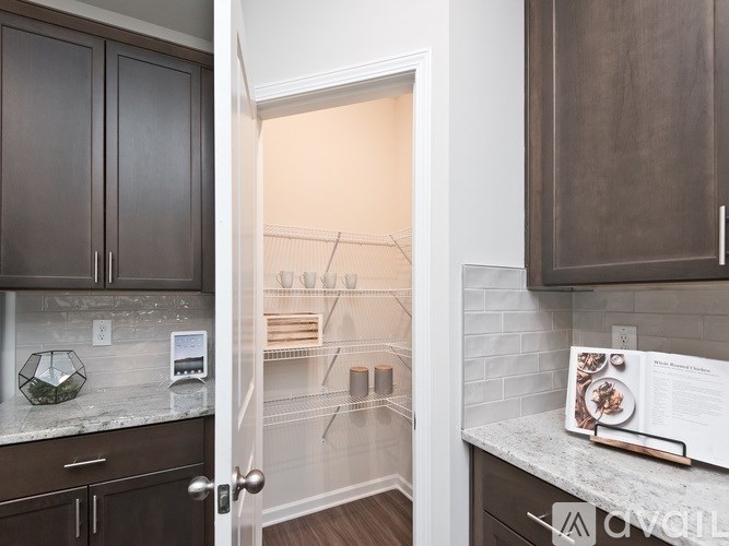 A kitchen with brown cabinets and a white door leading to a hallway.