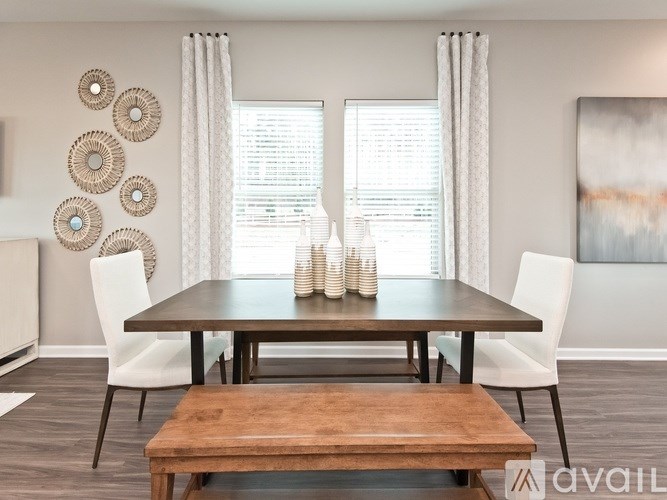 A dining room with a wooden table and white chairs.