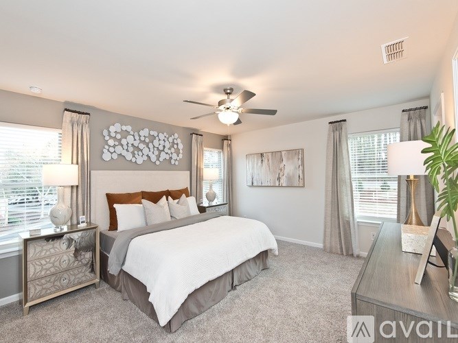 A bedroom with a large bed and a ceiling fan.