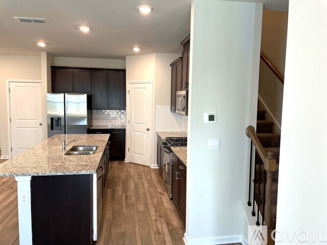 A kitchen with a granite countertop and stainless steel appliances.