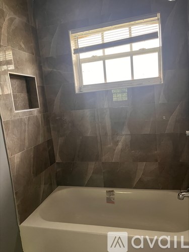 A bathroom with a tub and a window.