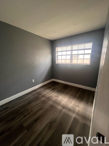 A room with wooden flooring and a window.