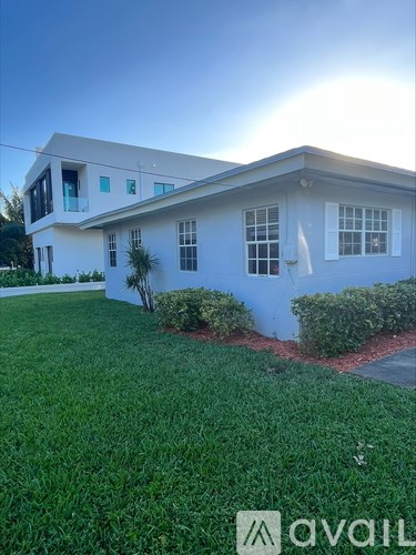 A white house with a green lawn in front.