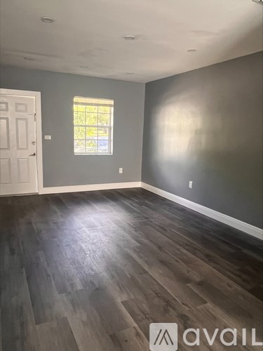 A room with wooden flooring and a window.