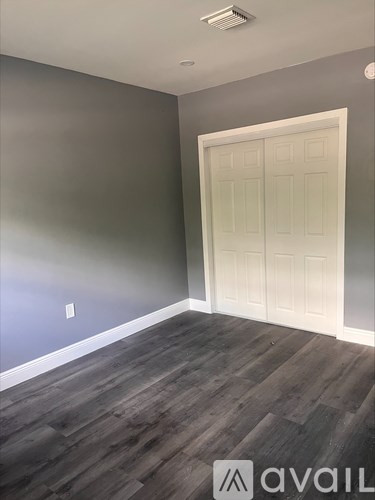 A room with a white door and grey walls.