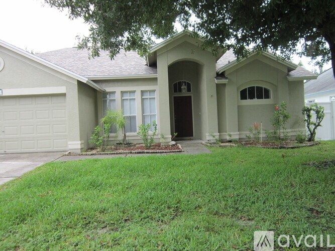 A house with a grey roof and a white garage door.