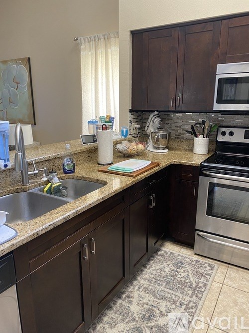 A kitchen with brown cabinets and a stainless steel oven.