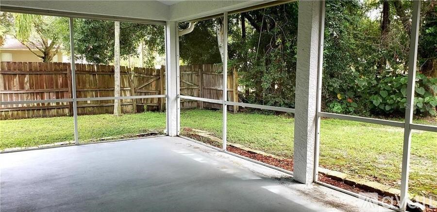 A patio with a white frame and a grey floor.