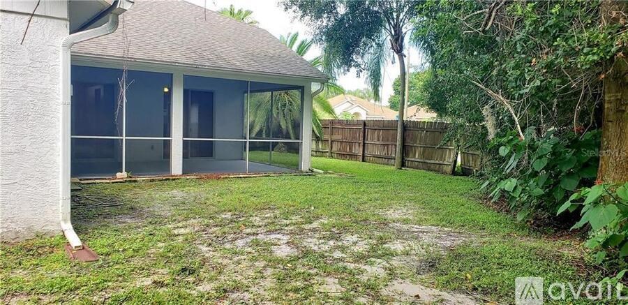 A backyard with a house and a fence.