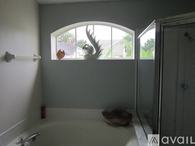 A bathroom with a tub, a window, and a door.