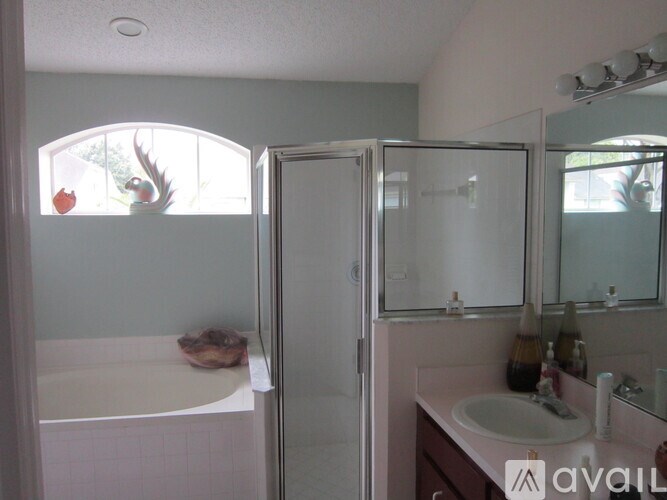 A bathroom with a white tub, sink, and shower.