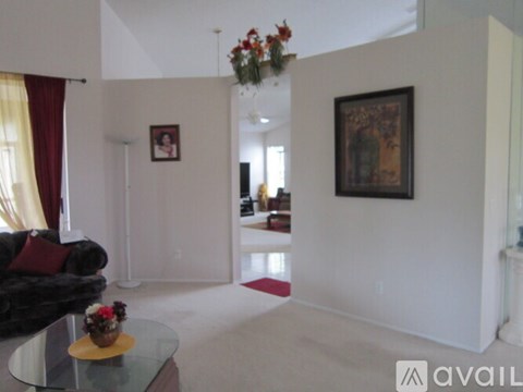 A living room with a couch, a coffee table, and a painting on the wall.