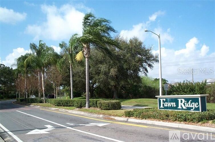 A street view of Fawn Ridge with a clear blue sky and palm trees.