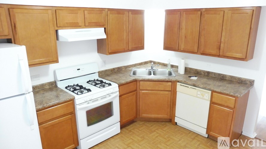 A kitchen with wooden cabinets and a white fridge.
