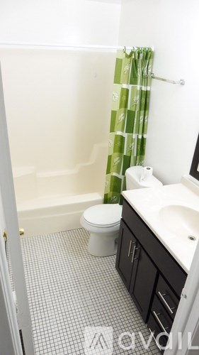 A white bathroom with a toilet, sink, and shower.
