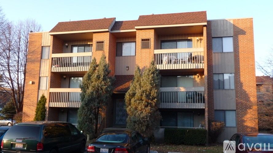 Apartment building with cars parked in front.